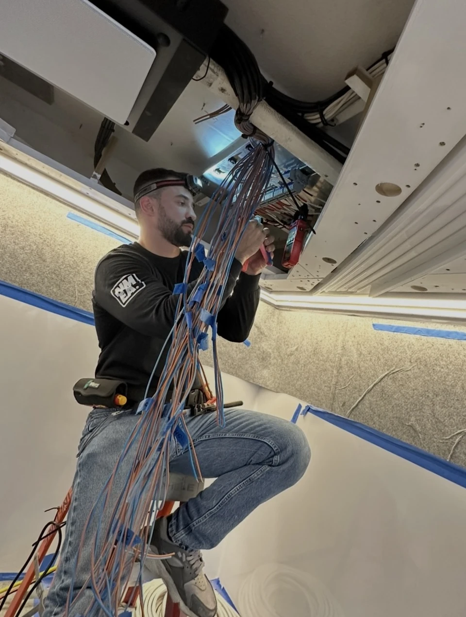 Marine electrical technician working on yacht wiring systems.